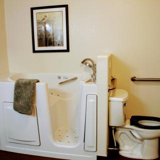 An accessible bathroom with a walk-in tub and grab bar.