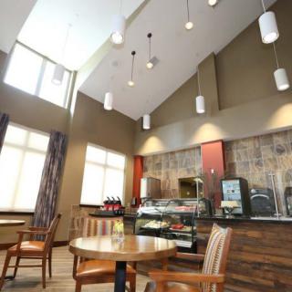 A modern cafe interior with seating and a beverage station.