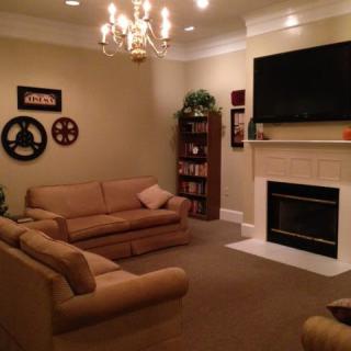 Cozy living room with a fireplace, sofas, and a TV.
