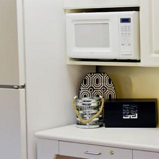 A kitchen area featuring a microwave, decorative items, and a refrigerator.