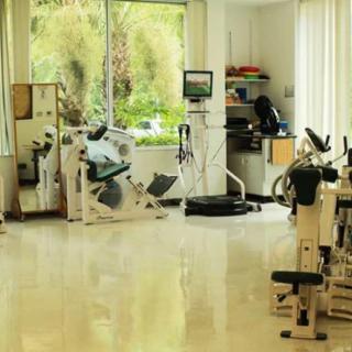 A well-lit gym with various exercise equipment.