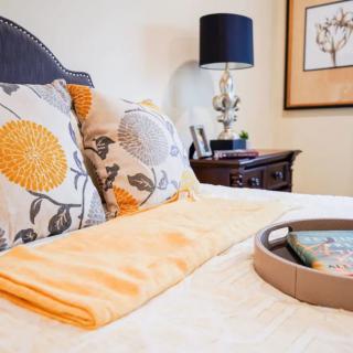 A cozy bedroom setup with decorative pillows and a stylish bedside table.
