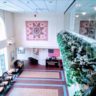 A spacious lobby featuring vibrant artwork, floral decorations, and a cozy seating arrangement.