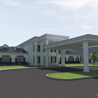 A modern building with a covered entrance and landscaped surroundings.