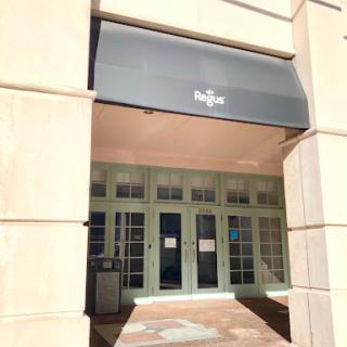 A storefront featuring a modern design with an awning and large glass doors.