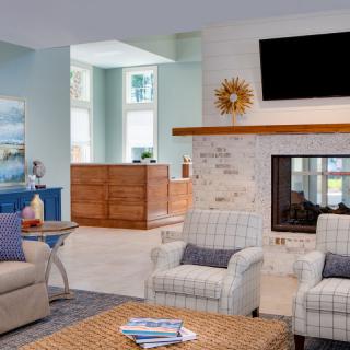 A modern living room with comfortable seating, a fireplace, and a TV mounted above it.