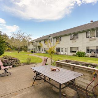 A serene outdoor patio area surrounded by lush greenery and residential buildings.