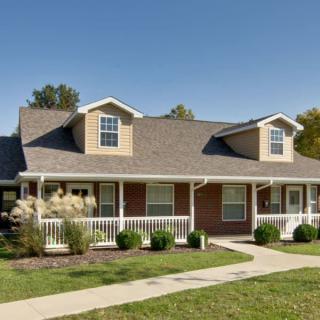 A suburban house with a well-maintained lawn and a welcoming porch.