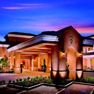 A luxurious hotel entrance illuminated at dusk.