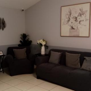 A modern living room with dark sofas and decorative artwork.