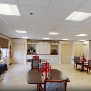 A well-lit meeting room with several tables and chairs arranged, featuring decorative items in the center of the tables.