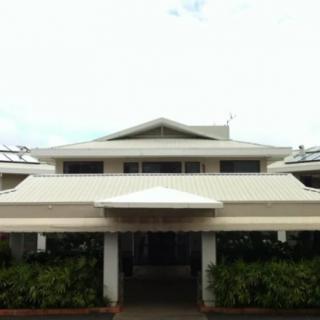 Front view of a multi-level building with a prominent roof design.