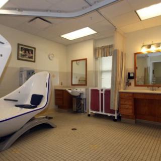 A well-equipped bathroom in a healthcare facility, featuring an accessible bathtub and modern amenities.