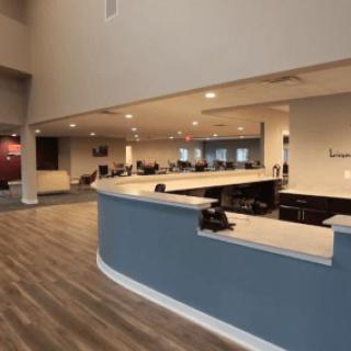 A modern office reception area with a curved desk and open seating.
