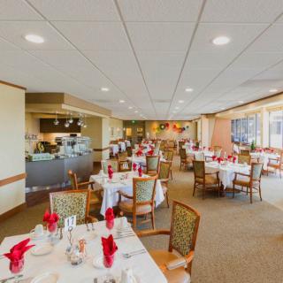 A spacious restaurant dining area with neatly arranged tables and chairs, featuring a warm and inviting interior design.