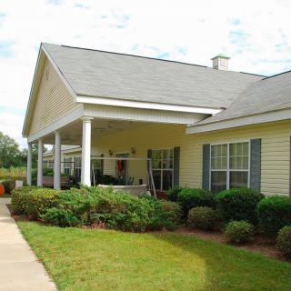 A suburban house with a porch and well-maintained lawn.