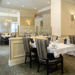 An elegantly set dining area in a restaurant with neatly arranged tables and chairs.