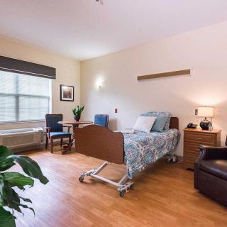A well-organized hospital room with a patient bed and comfortable seating.