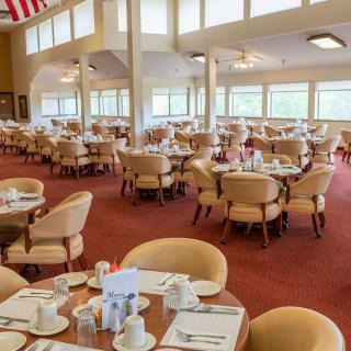 Spacious dining room with neatly arranged tables and chairs, ready for guests.