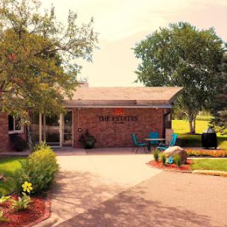 A welcoming entrance to a community building surrounded by lush greenery.