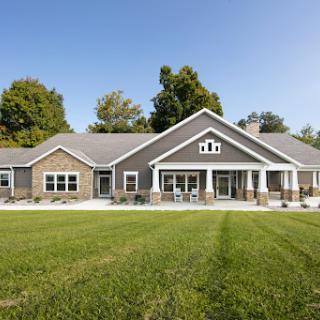 A spacious modern home with a beautifully landscaped yard under a clear blue sky.