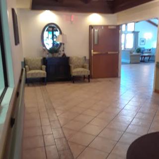 A well-lit interior lobby featuring a seating area with sofas and a decorative mirror.