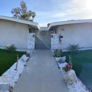 A pathway leading to a modern house with a landscaped garden.