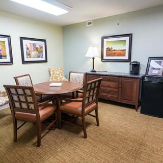 A small meeting room with a round table, chairs, and decorative artwork on the walls.