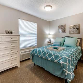 A cozy bedroom with teal bedding and elegant decor.