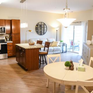 A modern open-concept kitchen and living area featuring wooden cabinetry and a cozy dining space.
