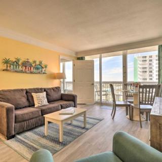A cozy apartment living room with a sofa, coffee table, and dining area, featuring a balcony with a city view.