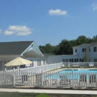 Residential area with a fenced outdoor swimming pool on a sunny day.