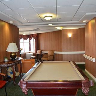 A cozy recreation room with a pool table and seating area.