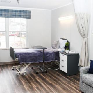 A modern hospital room with a medical bed and minimalist decor.