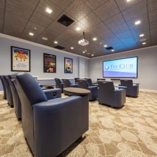 A cozy home theater room with comfortable seating and a large projector screen.
