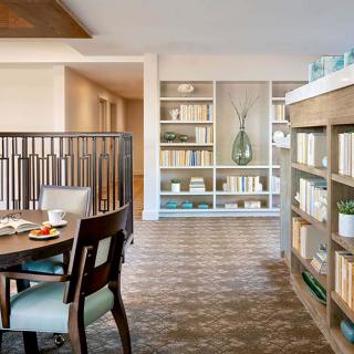 A modern open living space with a dining area and bookshelves.
