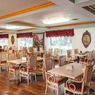 A cozy restaurant dining area featuring elegant tables and chairs with a warm interior design.