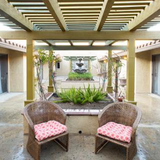 A serene courtyard featuring comfortable seating and lush greenery.
