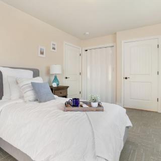 A cozy and minimalist bedroom with a neatly made bed and soft lighting.