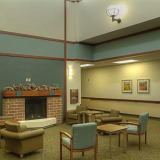 A modern lobby area with comfortable seating, featuring a fireplace and artwork on the walls.