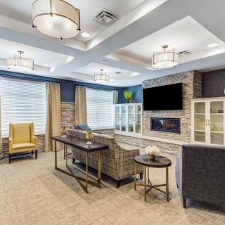A modern living room with stylish furniture, built-in fireplace, and a mounted television.