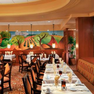 A beautifully decorated restaurant dining room with neatly set tables and eye-catching artwork on the wall.