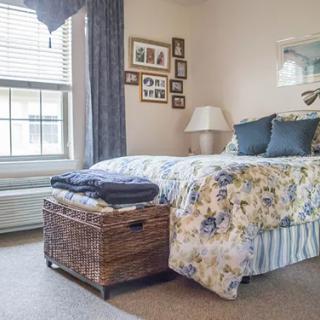 A cozy bedroom with a floral bedspread and wicker basket.