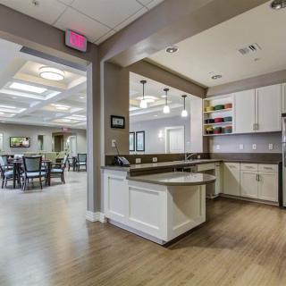 A modern kitchen and dining area with natural lighting and wood flooring.