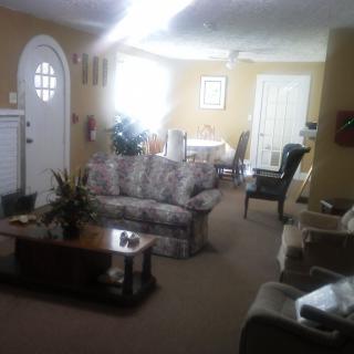 A cozy living room with a sofa, coffee table, and adjacent dining area.