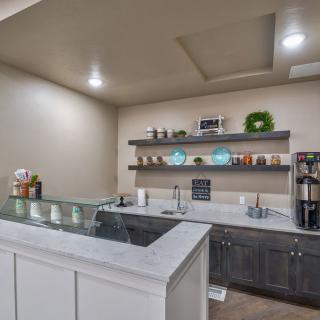 A modern kitchen with sleek countertops and open shelving, featuring various decor elements and appliances.