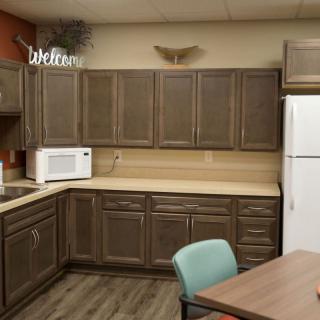 A cozy kitchen with wooden cabinets, a microwave, and a refrigerator.