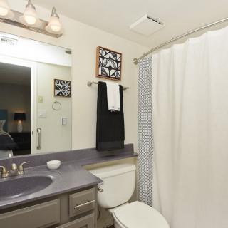 A modern bathroom featuring a sink, mirror, and shower area with a curtain.