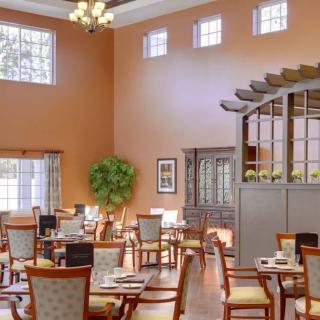 A well-lit dining area with neatly arranged tables and chairs.