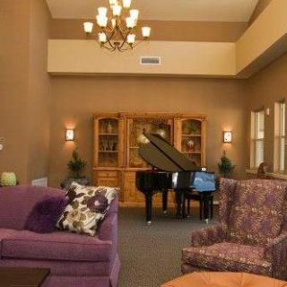 A cozy living room featuring a grand piano and elegant furniture.